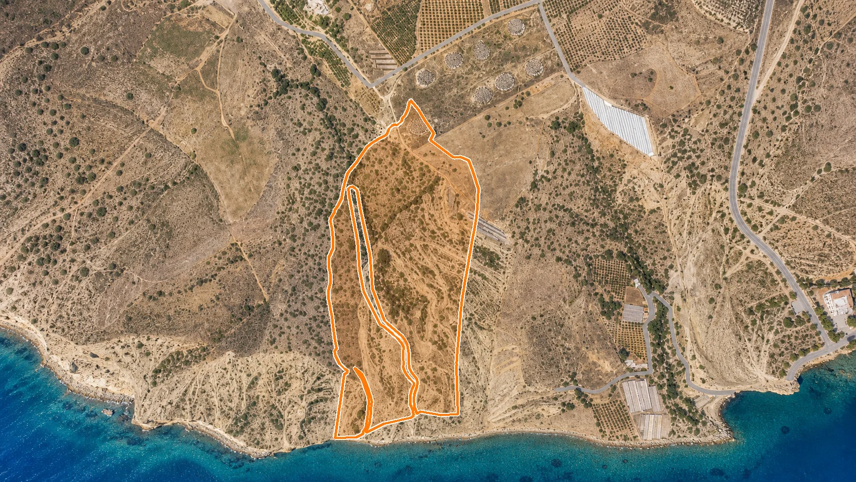 Satellite view of the site with the boundary outlined in orange, running down to the shoreline