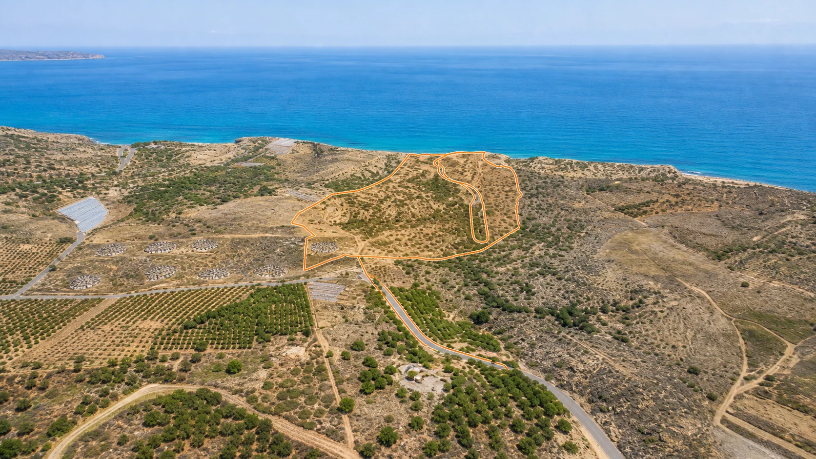 Oblique aerial view of the site looking towards the Libyan Sea, boundary outlined in orange